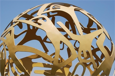 [ai] A spherical sculpture made of intertwined metallic shapes against a clear blue sky. The design features cut-out figures creating a dynamic and open structure.